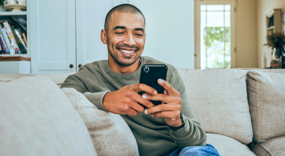 Mann auf Sofa mit Smartphone